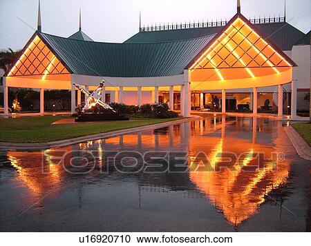 Stock Image -  Naples, FL, Florida, The Philharmonic Center for the Arts, evening, reflection in pool of water. Fotosearch