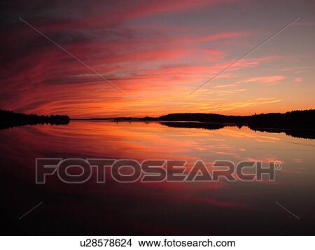 Picture -  New Brunswick, Bay of Fundy, Canada, Maces Bay, Colorful reflection at sunrise on the calm waters of the Bay of Fundy at sunset.. Fotosearch
