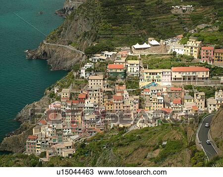 Stock Image -  Riomaggiore, Liguria, Italy, Cinque Terre, Riviera di Levante, Ligurian Riviera, Europe, Scenic view of Riomaggiore, a Cinque Terre village, along the steep rocky coastline of the Ligurian Sea.. Fotosearch