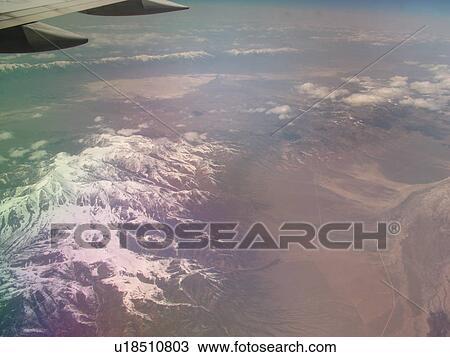 Stock Image -  Rocky Mountains, Aerial, wing, airplane flying over the snow-covered Rockies. Fotosearch
