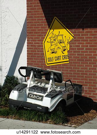Stock Image -  St. Augustine, FL, Florida, Golf Hall of Fame, World Golf Village, Golf cart in the side of a building with caution sign, St. Johns Cradle of Golf. Fotosearch