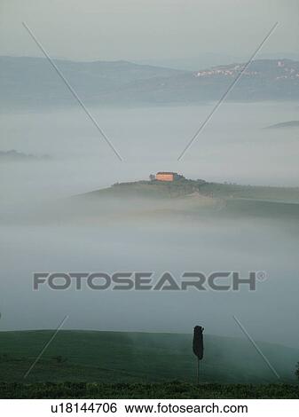 Stock Photograph -  Tuscany, Italy, Pienza, Toscana, Europe, Scenic view of a Tuscan home and the countryside of Tuscany in the fog in Pienza.. Fotosearch