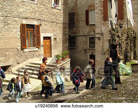 Stock Photograph -  Umbria, Italy, Narni, Europe, Group of young school children walking through the cobblestone street of Piazza Garibaldi in the medieval town of Narni.. Fotosearch