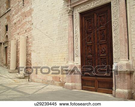 Stock Photography -  Umbria, Italy, Spello, Europe. The wooden door of the Chiesa di Santa Maria Maggiore in the medieval town of Spello.. Fotosearch