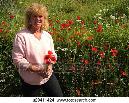 wildflowers, Tuscany, Italy, Cortona, Toscana, Europe, Woman standing in a field of wildflowers holding poppies. View Large Photo Image Picture - wildflowers, Tuscany, Italy, Cortona, Toscana, Europe, Woman standing in a field of wildflowers holding poppies.. Fotosearch