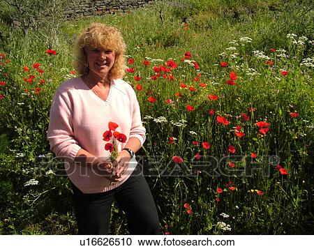 wildflowers, Tuscany, Italy, Cortona, Toscana, Europe, Woman standing in a field of wildflowers holding poppies. View Large Photo Image Stock Image - wildflowers, Tuscany, Italy, Cortona, Toscana, Europe, Woman standing in a field of wildflowers holding poppies.. Fotosearch