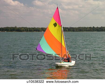 Stock Image -  Alexandria, MN, Minnesota, Maple Lake, couple sailing, sunfish, sailboat. Fotosearch