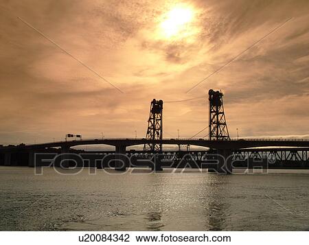 Stock Image -  Bath, ME, Maine, Kennebec River, bridge, sunrise. Fotosearch