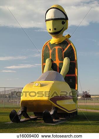 Stock Image -  Bottineau, ND, North Dakota, Bottineau City Park, 32 foot statue of Tommy Turtle on a snowmobile. Fotosearch