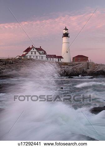 Stock Image -  Cape Elizabeth, ME, Maine, Portland Head Light Lighthouse, Fort Williams Park, sunset, waves crashing against the rocky coastline. Fotosearch