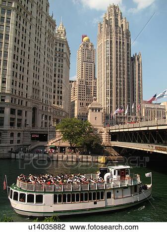 Stock Image -  Chicago, IL, Illinois, Windy City, Downtown, skyline, Michigan Avenue, Wrigley Building, Tribune Tower, sightseeing tour boat, Chicago River. Fotosearch