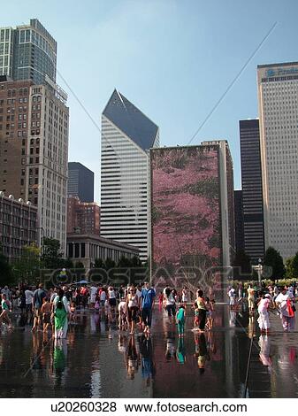 Stock Photo -  Chicago, IL, Illinois, Windy City, Downtown, Millennium Park, Crown Fountain, people cooling off, hot summer day, video image on wall, mural. Fotosearch