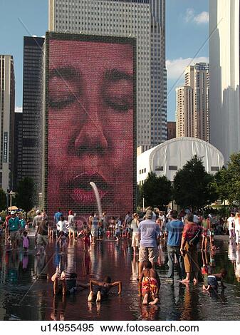 Stock Photography -  Chicago, IL, Illinois, Windy City, Downtown, Millennium Park, Crown Fountain, people cooling off, hot summer day, face, video image on wall, mural. Fotosearch