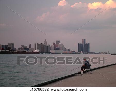 Stock Image -  Detroit, MI, Michigan, Downtown skyline, Detroit River, from Windsor, Ontario, Canada, fisherman. Fotosearch