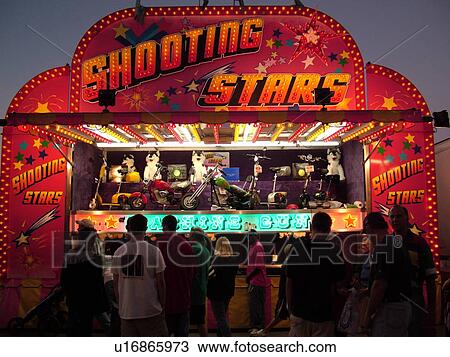 Stock Image -  Essex Junction, VT, Vermont, Champlain Valley Fair, Shooting Stars game on the Midway, evening. Fotosearch