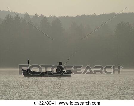 Stock Image -  Groton, VT, Vermont, Lake Groton, Groton State Forest, Man fishing, boat, fog. Fotosearch