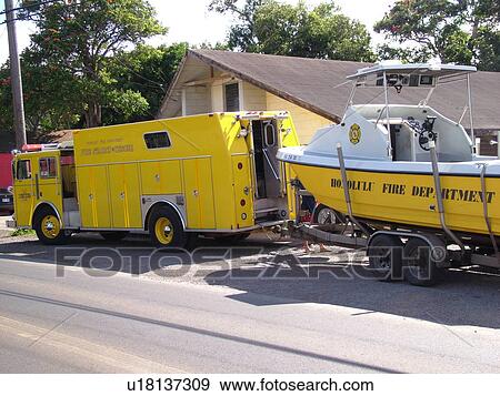 Stock Photo -  Haleiwa, Oahu, HI, Hawaii, North Shore, Yellow Fire Truck pulling yellow rescue boat. Fotosearch