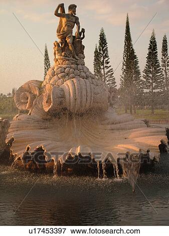 Stock Photo -  Hanalei, Princeville, Kauai, HI, Hawaii, North Shore, Fountain and statue of Neptune at the entrance of a resort complex, sunset. Fotosearch