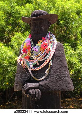 Stock Image -  Kamalo, Molokai, HI, Hawaii, East Molokai, Father Damien (Joseph de Veuster) statue, adorned with leis, St. Joseph Church. Fotosearch