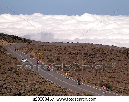 Stock Photo -  Maui, HI, Hawaii, Haleakala National Park, biking down the volcano, above the clouds. Fotosearch