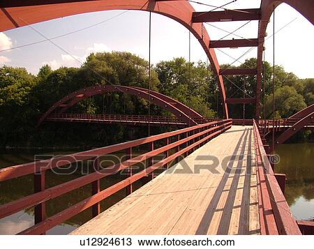 Stock Image -  Midland, MI, Michigan, The Tridge, three-legged pedestrian bridge crosses the Tittabawasee and Chippewa Rivers. Fotosearch