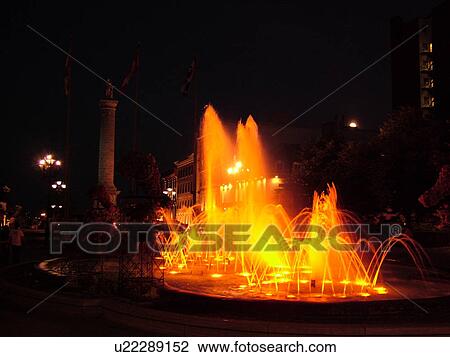 Stock Image -  Montreal, Canada, QC, Quebec, Old Port, Old Montreal, Place Jacques Cartier, Place Vauquelin, fountain, evening. Fotosearch