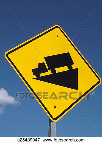 Stock Photo -  road sign, Hill, Steep Grade Ahead, trucks use low gear sign against a blue sky, warning sign. Fotosearch
