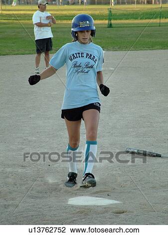 Stock Image -  St. Joseph, MN, Minnesota, Girls Babe Ruth Softball Game, Little League, Baseball, girl runs to home plate. Fotosearch
