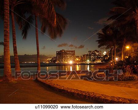 Stock Image -  Waikiki, Honolulu, Oahu, HI, Hawaii, Kuhio Beach Park, beachfront, skyline, evening. Fotosearch