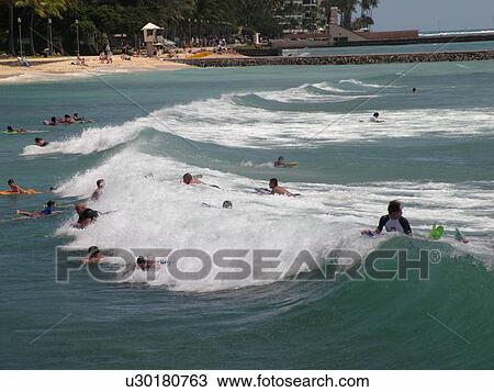 Stock Image -  Waikiki, Honolulu, Oahu, HI, Hawaii, Queen's Surf Beach, boogie boarding. Fotosearch