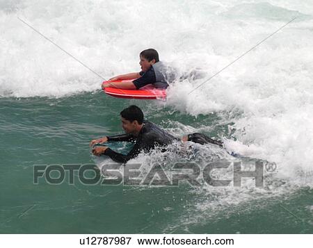 Stock Photo -  Waikiki, Honolulu, Oahu, HI, Hawaii, Queen's Surf Beach, boogie boarding. Fotosearch