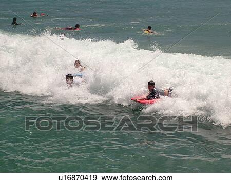 Stock Photo -  Waikiki, Honolulu, Oahu, HI, Hawaii, Queen's Surf Beach, boogie boarding. Fotosearch