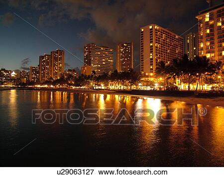 Stock Photo -  Waikiki, Honolulu, Oahu, HI, Hawaii, Kuhio Beach Park, beachfront, skyline, evening. Fotosearch