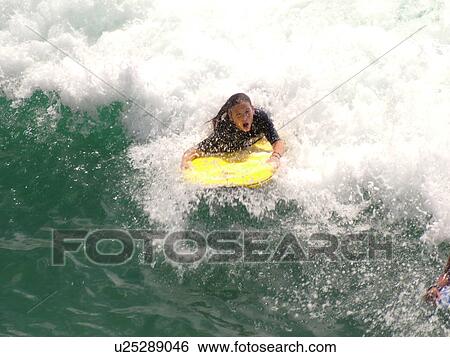 Stock Photograph -  Waikiki, Honolulu, Oahu, HI, Hawaii, Queen's Surf Beach, boogie boarding. Fotosearch
