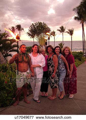 Stock Photo -  Wailea, Maui, HI, Hawaii, South Maui, The Fairmont Kea Lani Maui Resort, ladies posing with the torch lighter. Fotosearch