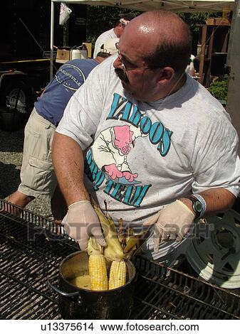 Picture -  Windsor, VT, Vermont, Harpoon Championships of New England Barbecue, Harpoon Brewery, Yahoos BBQ team selling roasted corn-on-the-cob dipped in melted butter. Fotosearch