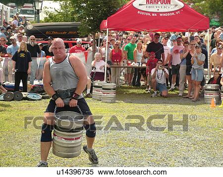 Stock Photography -  Windsor, VT, Vermont, Harpoon Championships of New England Barbecue, Strong Man Competition, man lifting and carrying full heavy keg of beer. Fotosearch