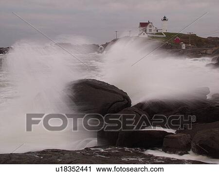 Stock Image -  York Beach, ME, Maine, Cape Neddick Nubble Light, Lighthouse, waves crashing against the rocky coast. Fotosearch