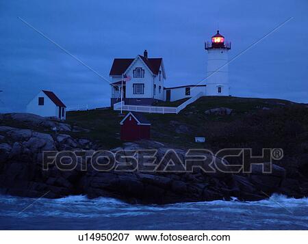 Stock Photo -  York Beach, ME, Maine, Cape Neddick Nubble Light, Lighthouse, evening. Fotosearch