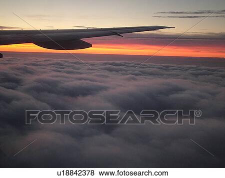 aerial, plane flying above the clouds, wing, sunrise View Large Photo Image Stock Photo - aerial, plane flying above the clouds, wing, sunrise. Fotosearch