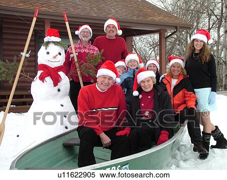 Stock Photography -  Alexandria, MN, Minnesota, Maple Lake, Family wearing red Santa hats posing for Christmas picture sitting in a green rowboat in the snow, humor, winter, snowman. Fotosearch