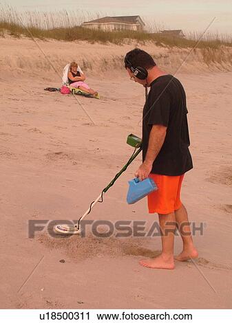 Stock Image -  Amelia Island, FL, Florida, Fernandina Beach, Atlantic Ocean, man on beach with metal detector. Fotosearch