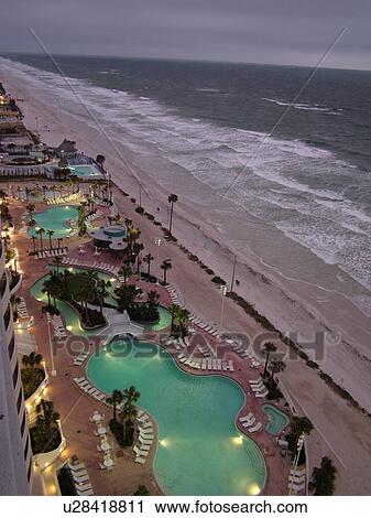 Stock Image -  Daytona Beach, FL, Florida, Atlantic Ocean, aerial, swimming pools, pool lights, Fairfield Resorts at Ocean Walk, Ocean Walk Resorts, beaches, evening. Fotosearch