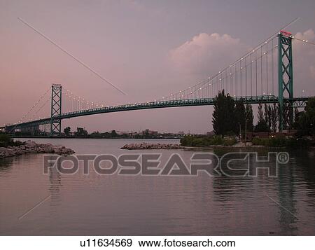 Stock Photo -  Detroit, MI, Michigan, Detroit River, Windsor, Ontario, Canada, Ambassador Bridge, evening. Fotosearch