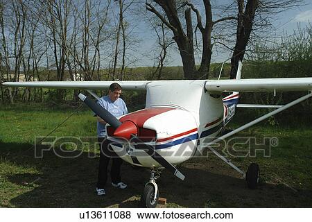 Flemington, NJ, New Jersey, man standing next to his small private plane View Large Photo Image Stock Photo - Flemington, NJ, New Jersey, man standing next to his small private plane. Fotosearch