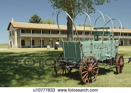 Stock Image -  Fort Laramie, WY, Wyoming, Fort Laramie National Historic Site, Calvary Barracks, covered wagon. Fotosearch