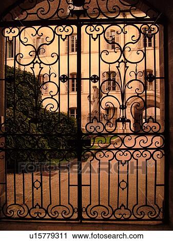 Stock Image -  France, Beaune, Burgundy, Cote de Beaune, Cote d'Or, Europe, Burgundy Wine Region, downtown, Hotel-Dieu, wrought iron gate. Fotosearch