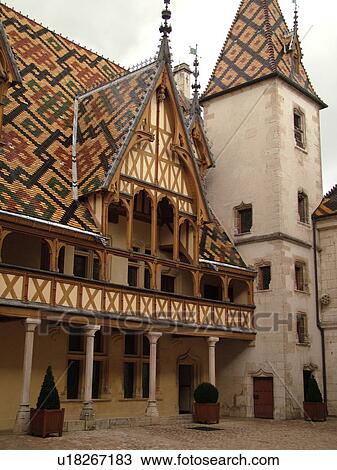 Stock Image -  France, Beaune, Burgundy, Cote de Beaune, Cote d'Or, Europe, Burgundy Wine Region, downtown, Hotel-Dieu, multi-colored Burgundian roof tiles. Fotosearch