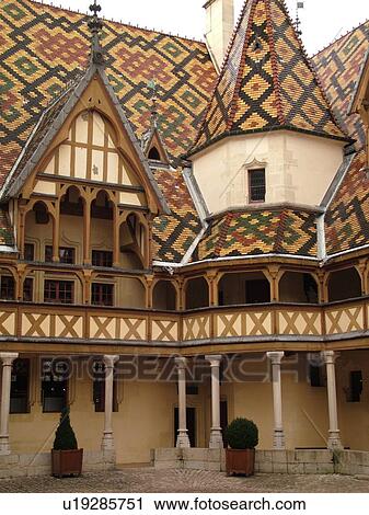 Stock Image -  France, Beaune, Burgundy, Cote de Beaune, Cote d'Or, Europe, Burgundy Wine Region, downtown, Hotel-Dieu, multi-colored Burgundian roof tiles. Fotosearch
