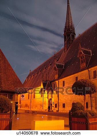 Stock Photo -  France, Beaune, Burgundy, Cote de Beaune, Cote d'Or, Europe, Burgundy Wine Region, downtown, Hotel-Dieu, evening. Fotosearch